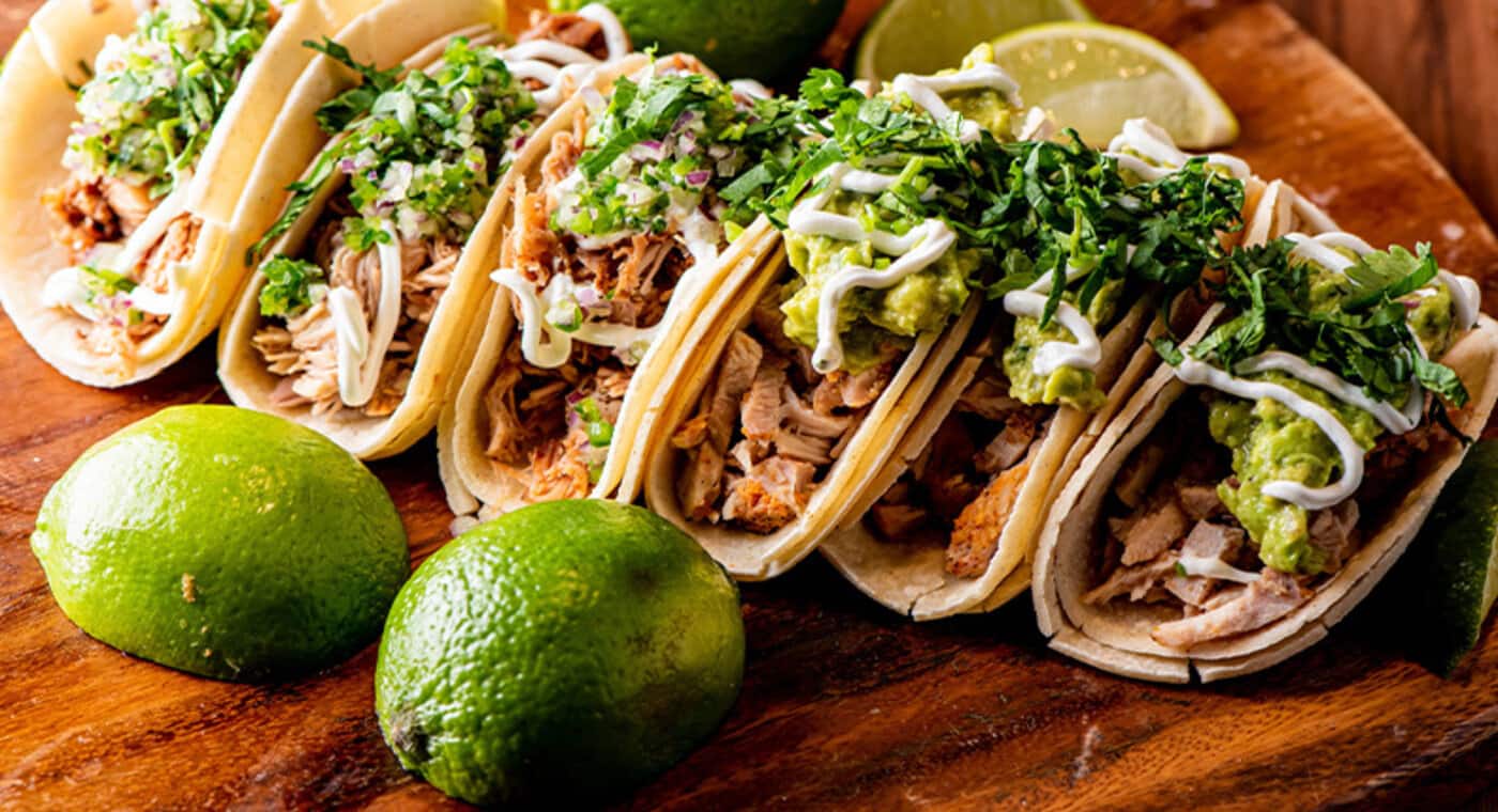 Tacos na drewnianej desce z limonkami - zdjęcie.