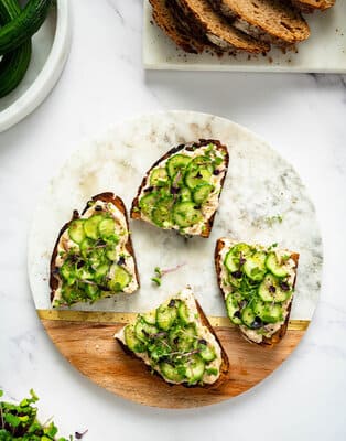 Toasted bread with mashed beans, cucumber and micro greens