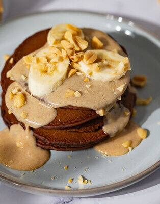 Chocolate pancakes with banana and peanut sauce