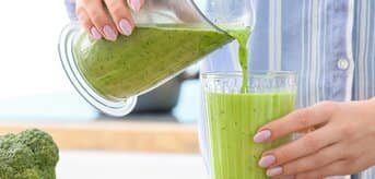  Kobieta nalewa zielony koktajl do szklanki