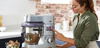 Kobieta obsługująca robota planetarnego Cooking Chef XL z warzywkami - zdjęcie.