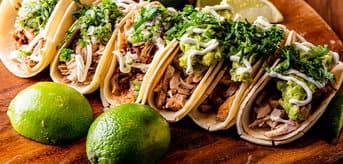 Tacos na drewnianej desce z limonkami - zdjęcie.