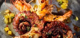 Grillowane krewetki z ośmiornicą i salsą ananasową. - zdjęcie