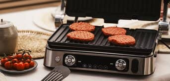 Braun MultiGrill grillujący burgery na stole - zdjęcie.