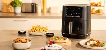 Na blacie kuchennym airfryer MultiFry 5 marki Braun oraz dania przygotowane za pomocą tego urządzenia. - tytułowa