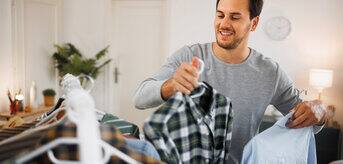 A man displaying a shirt on a rack.