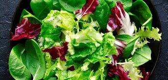 Liście szpinaku i sałaty leżące na talerzu