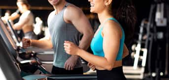 Kobieta i mężczyzna korzystający z bieżni. - zdjęcie