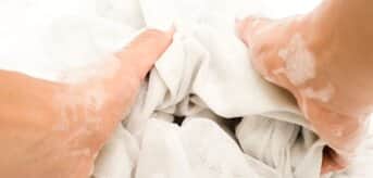 Ręce piorące biały materiał - zdjęcie