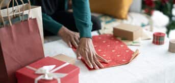 Osoba pakująca prezent - zdjęcie.