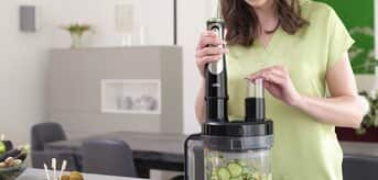 Kobieta kroi warzywa za pomocą blendera ręcznego Braun MultiQuick 9