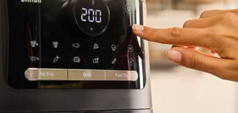 Ręka wciskająca przycisk na airfryerze marki Braun. - zdjęcie