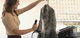 Kobieta prasuje kurtkę żelazkiem z generatorem pary Braun