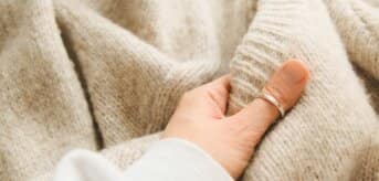 Dłoń dotykająca wełny - zdjecie.