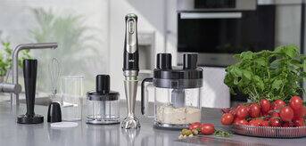 Braun MultiQuick 9 Hand blender standing on a kitchen counter next to various versatile attachments
