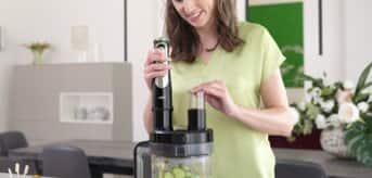 Kobieta krojąca w plasterki warzywa na zupę - zdjęcie