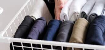 Ręka układająca ubrania w koszyku