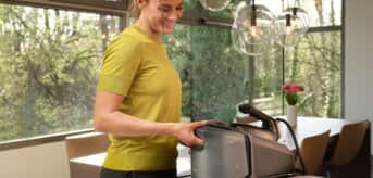 Kobieta wyjmująca pojemnik na wodę w żelazku z generatorem pary Braun CareStyle7Pro