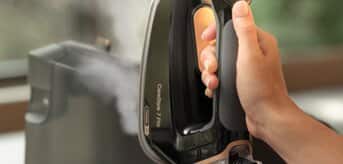 Ręka trzymająca generator pary Braun CareStyle 7 Pro z włączonym trybem iCare - zdjęcie