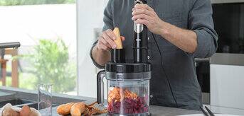 Braun MultiQuick 9 Hand blender with food processor attachment in use to dice vegetables.