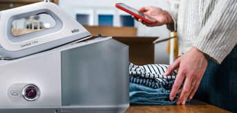 Na pierwszym planie żelazko z generatorem pary Braun CareStyle 7 Pro