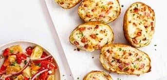 Faszerowane pieczone ziemniaki z sałatką z warzywami. - zdjęcie