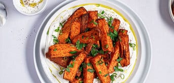 Frytki z batatów na białym talerzu. - zdjęcie