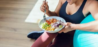 Kobieta jedząca po treningu. - zdjęcie