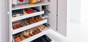 Szafa z poukładanymi w szufladzie butami