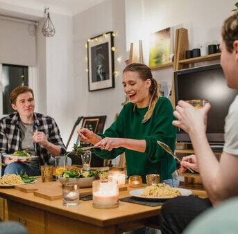 A group of four people gathered around a table, sharing a meal and engaging in conversation.